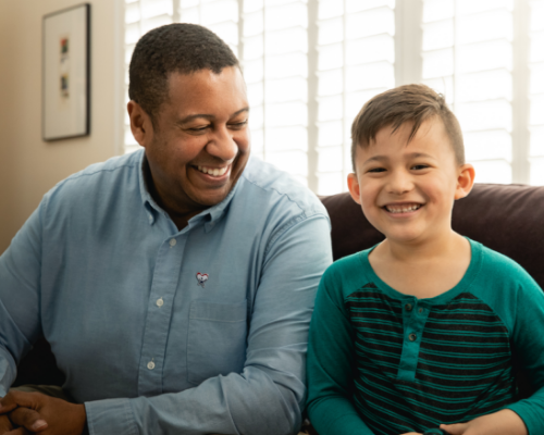 adult volunteer sitting and smiling with child