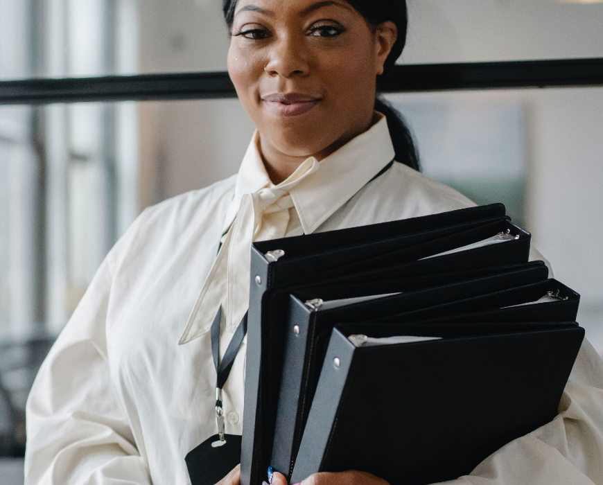 woman carrying binders in arms woman carrying binders in arms