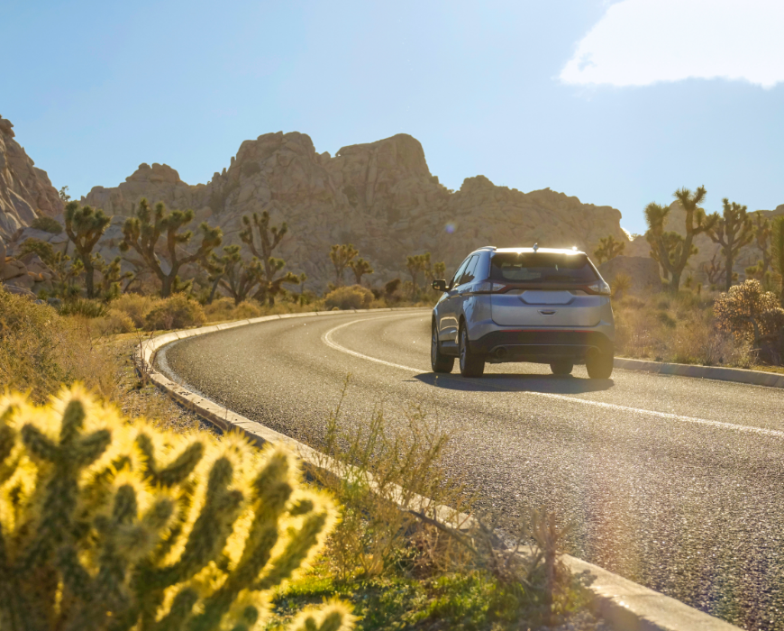 vehicle driving down road in desert vehicle driving down road in desert