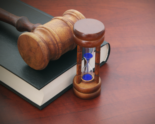 gavel on top of book next to hourglass